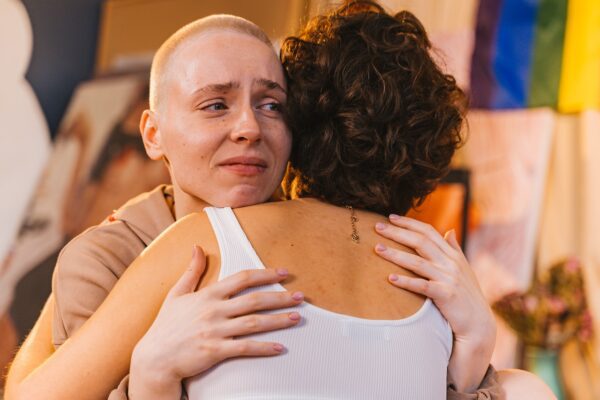 woman hugging another sad woman