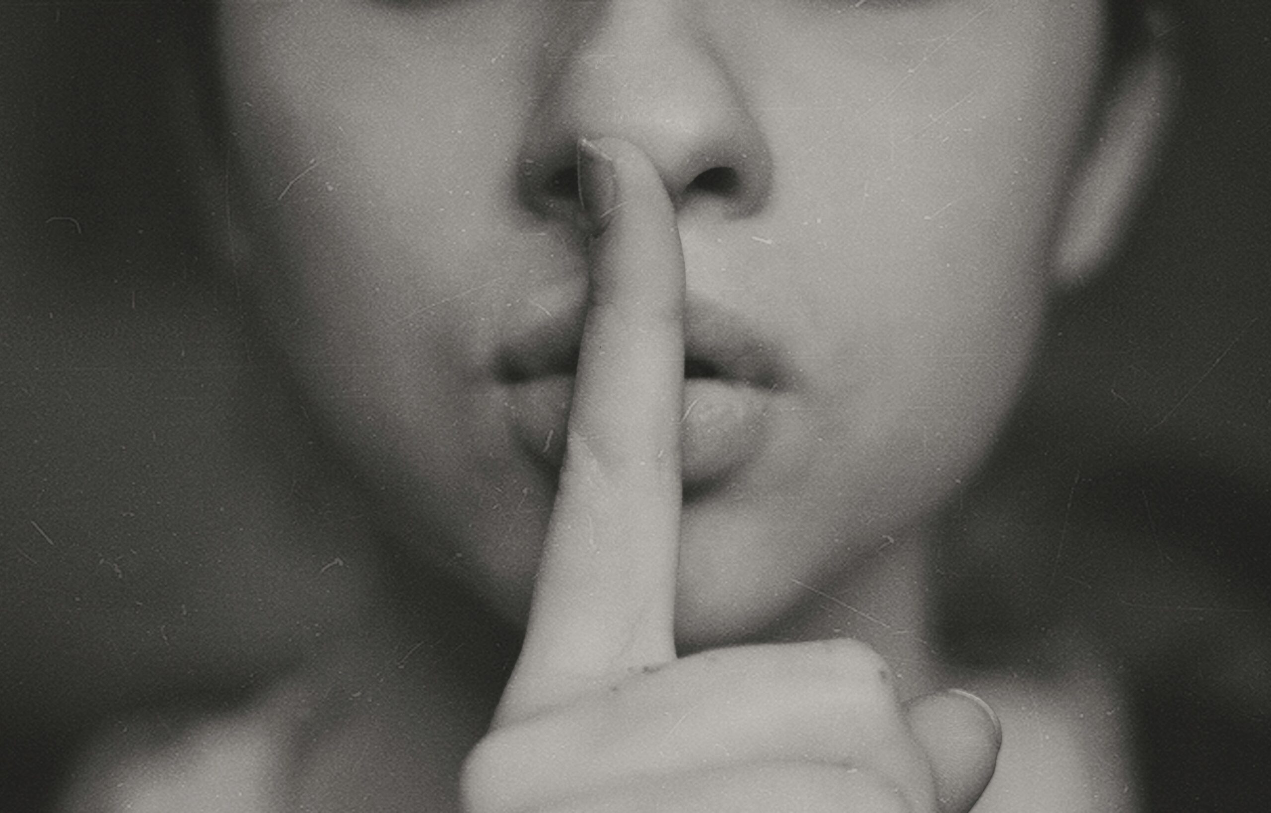 Greyscale woman putting finger to lips