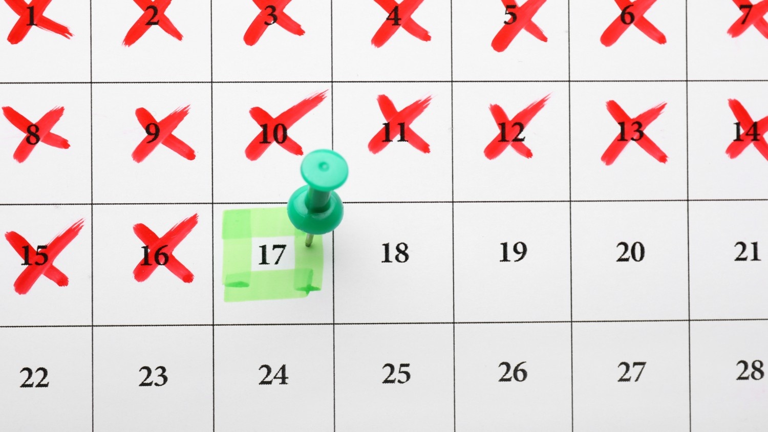A calendar with red x’s leading up to a date marked with a green pin and marker.